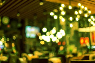 Küçük bir restoranın içi bulanık bir arka plan. Bokeh Kafe 'nin içini sıcak koyu renklerle bulanıklaştırmış. Yaratıcı moda tasarımı için arka plan olarak.
