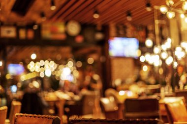 Küçük bir restoranın içi bulanık bir arka plan. Bokeh Kafe 'nin içini sıcak koyu renklerle bulanıklaştırmış. Yaratıcı moda tasarımı için arka plan olarak.