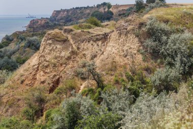 Çevreye zararlı bir bölgede dağ heyelan. Yeryüzündeki büyük çatlaklar, toprak yolu kapatan büyük katmanların inişi. Dağ yamacının yamacında baraj tehlikesi