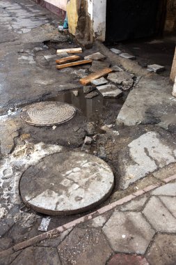 Çukurlar, kışın donma-çözülme çevrimleri neden olan bozuk asfalt yol. Kötü yol. Kaldırımlar kaldırımlar kaldırımda kırık. kaldırım döşeme ile kusurları ile tabaka ve perspektif içinde gelen çatlaklar