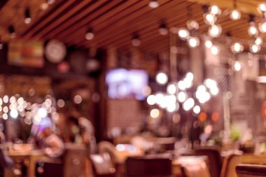 Küçük bir restoranın içi bulanık bir arka plan. Bokeh Kafe 'nin içini sıcak koyu renklerle bulanıklaştırmış. Yaratıcı moda tasarımı için arka plan olarak.