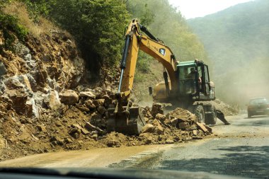 Rila Manastırı, Bulgaristan - 30 Temmuz 2016: dağ yolu genişletmek için inşaatı işi. Modern yol yapım ekipmanları çalışır. Dar geçit. Kapalı yol. Karayolu onarım çalışmaları