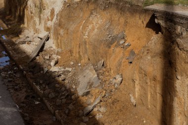 Eski beton ve paslı metal, demir döküm drenaj boruları ve şantiye topraklarında. Konsolide edilen Atıksu sistemi, yere fırlattı. Onarım drenaj çukuru yağmur suyu drenaj sistemi