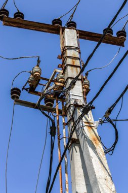 Elektrik direği, yüksek voltajlı elektrik desteği teller ve mavi gökyüzü iletişim seramik izolatörler ile. Enerji arzı, elektrik transit kavramı. Tedarik ve transit enerji kaynaklarının