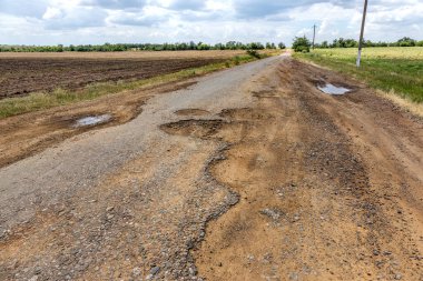 Bozuk yol çukurların ve noktalar, Ukrayna kırık asfalt kılıçla. Büyük delikli çok kötü asfalt yol. Korkunç teknoloji inşaat yollar. Çok sayıda tehlikeli hataları. Kötü yol. Yol onarım