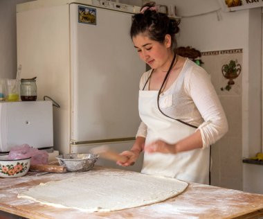 Sudak, Rusya Federasyonu - 15 Mayıs 2015: Genç güzel kız hamur rulo ve ulusal Kırım Tatar yemek pasties küçük bir mutfak, bir fast food restoran hazırlamak. Kırım - Tatar ulusal mutfağı