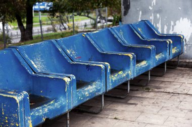 Seyirci için boş eski plastik sandalyeler. Eski küçük yerde boş koltuk sayısı. Çizik aşınmış mavi plastik koltuk önemli fan ziyaretçiler için. Satır plastik fiberglas koltukları platformu feribot otobüste