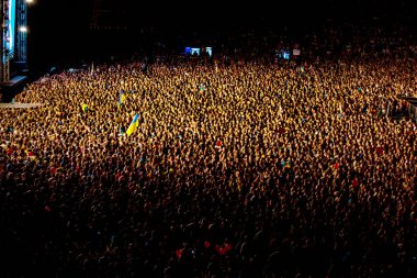 Odessa, Ukrayna - 28 Haziran 2014: Ukrayna grubunun Okean Elzy yaratıcı ışık ve müzik gösterisi sırasında bir konserde stadyumda eğlenmek insanların büyük bir kalabalık. Kulüp partisinde neşeli parlak gösteri