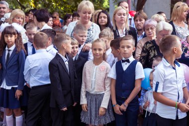 Odessa, Ukrayna 1 Eylül 2017: Okul bahçesinde öğrenciler ve öğretmenler ile okul çizgi var. Çocuklar okula geri dön. Bilgi gün, okulun ilk günü. Birinci sınıf öğrencileri sınıfta oturmak