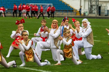 Odessa, Ukrayna - 21 Ekim 2017: Sahne alanı'nda çocuk. Genç çocuk topluluğu Stadyumu yeşil çimenlerin üzerinde Ulusal kostüm dans dans. Stadyumda dans çocuk