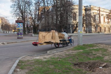 Odessa, Ukrayna - 29 Şubat 2017: Bir bisiklet üzerinde oturan evsiz biri Bagaj ile uyuyor. Evsiz bir bisiklet üzerinde yaşıyor ve yolun tam evinin karton kutu uyur