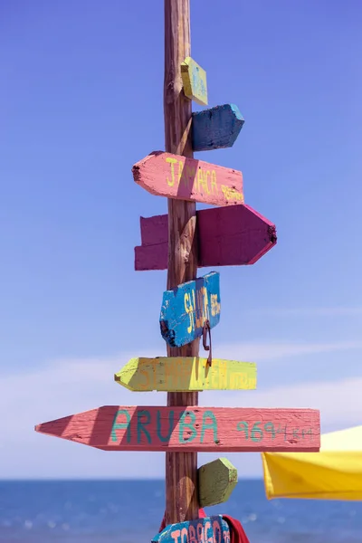 Wooden signpost on the beach of Varna, Bulgaria with pointers of the name and distance to the places. Creative vintage wooden pillar with direction indicator on wooden colored arrowheads