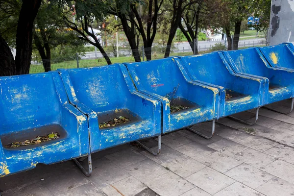 Empty old plastic chairs for spectators. Number of empty seats in old small place. Scratched worn blue plastic seats for important fan visitors. Rows of plastic fiberglass chairs on platform ferry bus