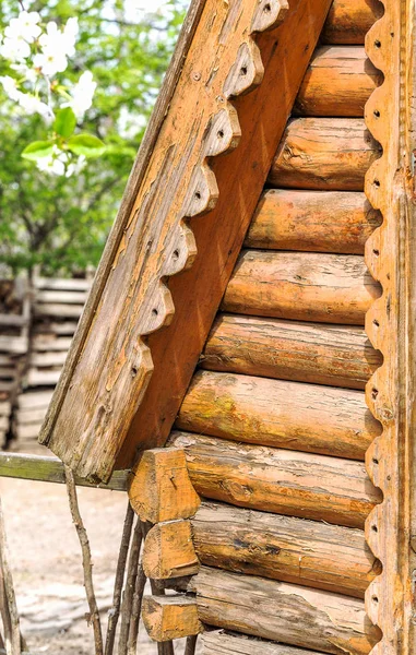 Detail of wooden beams in the wall of the round log home built on old technology as a creative element to natural background