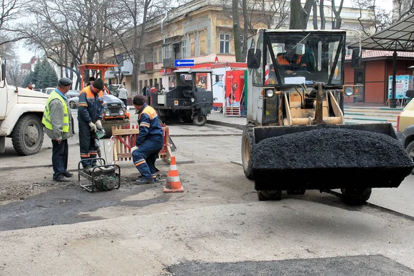 Odessa - April 3: a team of workers repairs road under the program of urban planning repairs after winter frosts that destroyed an asphalt road . April 3, 2014 in Odessa, Ukraine