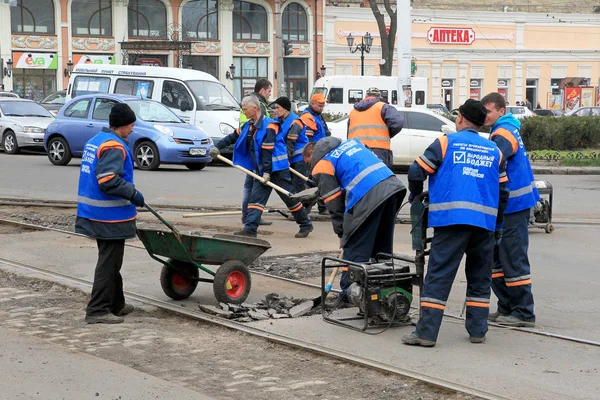 Odessa - April 3: a team of workers repairs road under the program of urban planning repairs after winter frosts that destroyed an asphalt road . April 3, 2014 in Odessa, Ukraine