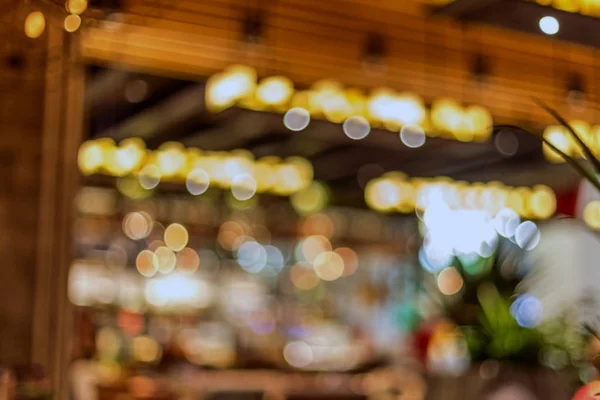 The interior of a small restaurant a blurred background. Blurred bokeh cafe interior in warm dark colors. As background for creative fashion design.