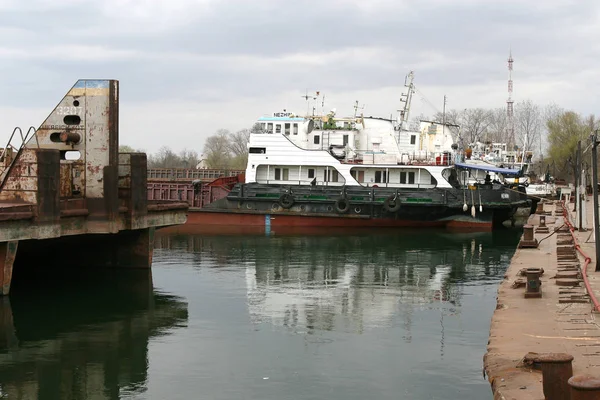 ODESSA April 15: Old river trading port Ust -Danube . Human outdated repair river vessels , barges at the shipyard docks. Ancient Technology , April 15, 2014 Odessa, Ukraine