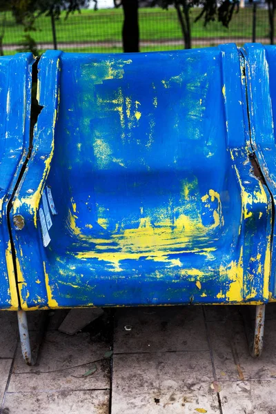 Empty old plastic chairs for spectators. Number of empty seats in old small place. Scratched worn blue plastic seats for important fan visitors. Rows of plastic fiberglass chairs on platform ferry bus