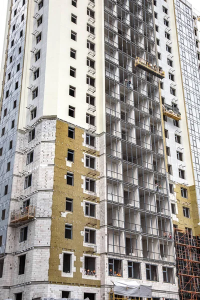 ODESSA, UKRAINE - JUNE 18 2014: Construction of a high-rise residential building works on the outer facade of the building insulation, insulation. Modern technology in the construction of thermal insulation — Stock Image Odessa Ukraine June 2014 Construction High Rise Residential Building Works Stock Image