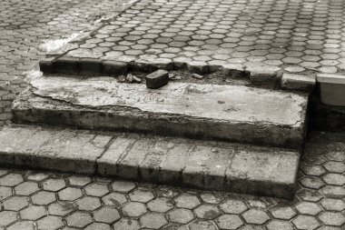 Eski, açık, taştan bir merdiven. Taş, eski merdivenlerin çimento basamaklarında yıpranma ve yıpranma izleri var. Eski taş bir merdiven, eski kırık basamaklar. Seçici odak