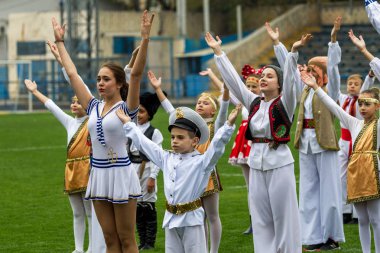 Odessa, Ukrayna - 21 Ekim 2017: Sahne alanı'nda çocuk. Genç çocuk topluluğu Stadyumu yeşil çimenlerin üzerinde Ulusal kostüm dans dans. Stadyumda dans çocuk