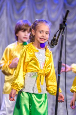 Odessa, Ukrayna - 24 Aralık 2015: şarkı ve parlak renkli kıyafetler içinde sahnede dans çocuk müzik grupları. Duygusal, çocukların müzik sahne gösterisi dokunmadan.