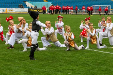 Odessa, Ukrayna - 21 Ekim 2017: Sahne alanı'nda çocuk. Genç çocuk topluluğu Stadyumu yeşil çimenlerin üzerinde Ulusal kostüm dans dans. Stadyumda dans çocuk