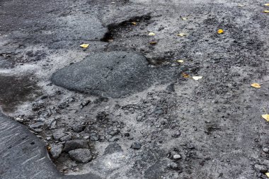 Bozuk asfalt yol çukurların donma-çözülme tarafından neden ile bir kış aylarında geçer. Kötü yol. Yol onarım