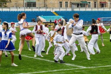 Odessa, Ukrayna - 21 Ekim 2017: Sahne alanı'nda çocuk. Genç çocuk topluluğu Stadyumu yeşil çimenlerin üzerinde Ulusal kostüm dans dans. Stadyumda dans çocuk
