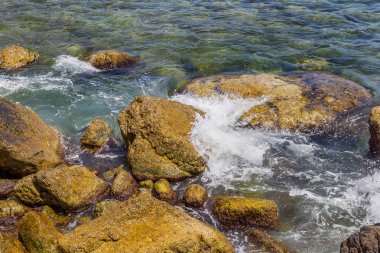 Büyük dalga sıçrama. Deniz suyu kayalar ve kayalıklarla karşı yenerek. Yukarıda ferahlatıcı güneş Zenit Beach'te mavi gökyüzü okyanus su damla.