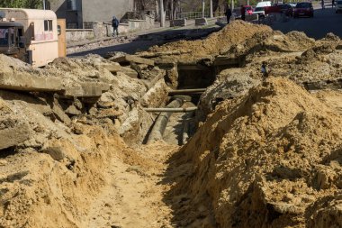 Odessa, Ukrayna - 25 Nisan 2017: Metro siperlerine komün için. İnşaat işçileri döşeme ve Metro araçları veya hizmet borular inşaat sitede yükleme için siperler kazmak.