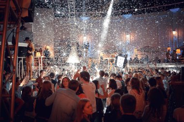 Odessa, Ukrayna - 24 Mayıs 2014: Kalabalık insan yaratıcı ışık ve müzik gösterisi sırasında bir konserde bir gece kulübünde eğleniyor. Konfeti ve büyük tiyatro kulübü parti üzerinde duman yağmuruna neşeli gençler.