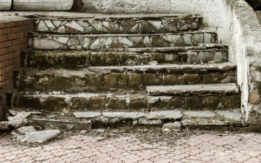 Eski, açık, taştan bir merdiven. Taş, eski merdivenlerin çimento basamaklarında yıpranma ve yıpranma izleri var. Eski taş bir merdiven, eski kırık basamaklar. Seçici odak