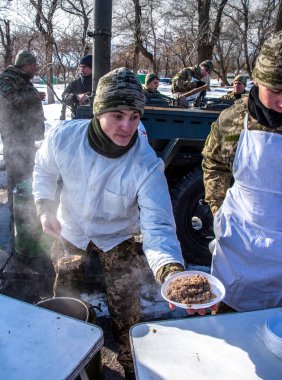 Odessa, Ukrayna - 19 Ocak 2016: Ukrayna ordusu alanın mutfakta yemek hazırlama ve askeri buğday dondurucu kurtarma ekipleri ve evsizler sokakta sırasında ağır frosts beslemeleri. Kurtuluş kışın insanlara yardım etmek,
