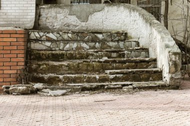 Eski, açık, taştan bir merdiven. Taş, eski merdivenlerin çimento basamaklarında yıpranma ve yıpranma izleri var. Eski taş bir merdiven, eski kırık basamaklar. Seçici odak
