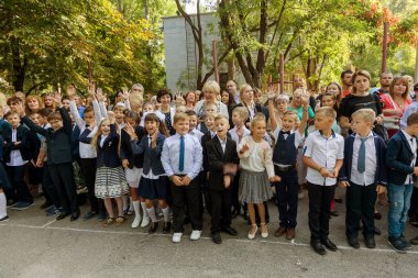 Odessa, Ukrayna 1 Eylül 2017: Okul bahçesinde öğrenciler ve öğretmenler ile okul çizgi var. Çocuklar okula geri dön. Bilgi gün, okulun ilk günü. Birinci sınıf öğrencileri sınıfta oturmak