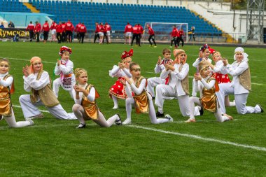 Odessa, Ukrayna - 21 Ekim 2017: Sahne alanı'nda çocuk. Genç çocuk topluluğu Stadyumu yeşil çimenlerin üzerinde Ulusal kostüm dans dans. Stadyumda dans çocuk