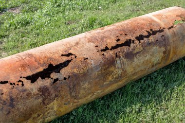 Eski büyük su boruları parçaları. Sonra uzun yıllar çalışma aşınmış metal boru yok. Paslı çelik boru delik metal korozyon ile. Seçici odak.