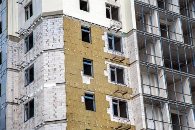 Odessa, Ukrayna - 18 Haziran 2014: Yüksek katlı konut bina inşaatı yapı izolasyon, izolasyon dış cephe üzerinde çalışır. Isı yalıtımı yapımında modern teknoloji