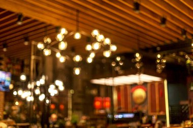 Küçük bir restoranın içi bulanık bir arka plan. Bokeh Kafe 'nin içini sıcak koyu renklerle bulanıklaştırmış. Yaratıcı moda tasarımı için arka plan olarak.