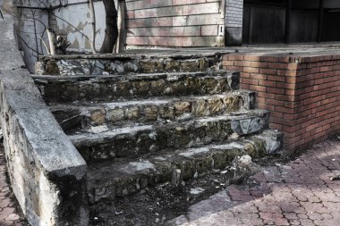 Eski, açık, taştan bir merdiven. Taş, eski merdivenlerin çimento basamaklarında yıpranma ve yıpranma izleri var. Eski taş bir merdiven, eski kırık basamaklar. Seçici odak