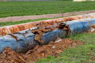 Eski büyük su boruları parçaları. Sonra uzun yıllar çalışma aşınmış metal boru yok. Paslı çelik boru delik metal korozyon ile. Seçici odak.