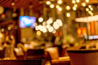 Küçük bir restoranın içi bulanık bir arka plan. Bokeh Kafe 'nin içini sıcak koyu renklerle bulanıklaştırmış. Yaratıcı moda tasarımı için arka plan olarak.
