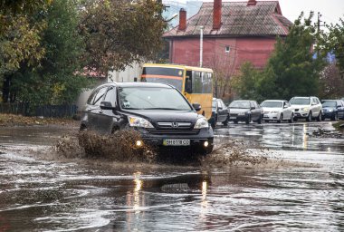 Odessa, Ukrayna - 21 Ekim 2015: büyük su birikintileri sokaklarında şiddetli yağışlar sonucu sular altında. Su ve kir yağmurda ıslak yolda ağır seyahat otomobil püskürtülür