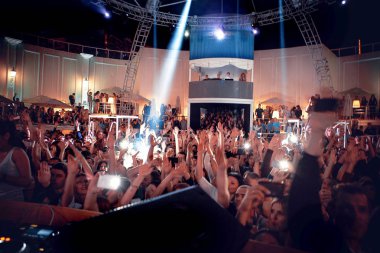 Odessa, Ukrayna - 24 Mayıs 2014: Kalabalık insan yaratıcı ışık ve müzik gösterisi sırasında bir konserde bir gece kulübünde eğleniyor. Konfeti ve büyük tiyatro kulübü parti üzerinde duman yağmuruna neşeli gençler.