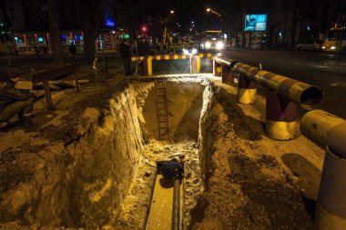 Odessa, Ukrayna - 10 Aralık 2015: inşaat işçileri Acil Onarım kentsel Karayolları geceleri mühendislik yapıyor. Onarım ve yedek su, Kanalizasyon borular alt kısmında derin bir siper gece boyunca. Kaza.