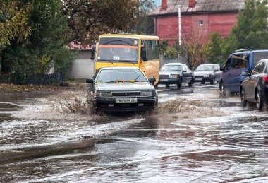 Odessa, Ukrayna - 21 Ekim 2015: büyük su birikintileri sokaklarında şiddetli yağışlar sonucu sular altında. Su ve kir yağmurda ıslak yolda ağır seyahat otomobil püskürtülür