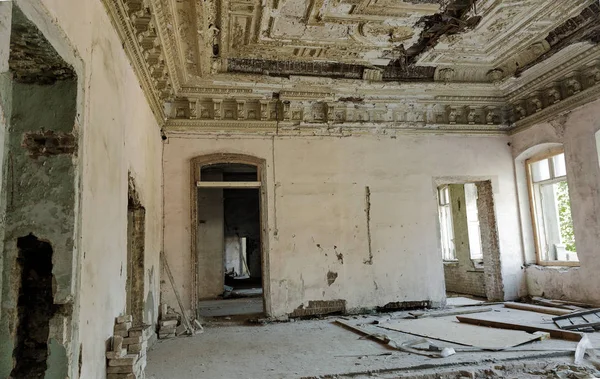 Mystical interior, ruins of an abandoned ruined building of an ancient 18th century building. Old ruined walls, corridor with garbage and mud. Destroyed molding, gypsum decorations, bas-relief