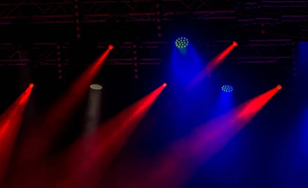Stage lights. Background in the show. Light in dark. The interior of the theater is illuminated by projector. Stage lights and smoke scenes during the concert. Laser show on the stage of theater